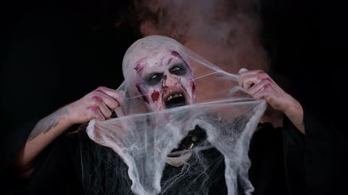 Creepy Zombie in Costume with Spiderwebs Growling
