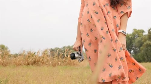 Woman Taking Photos with Vintage Camera in Field