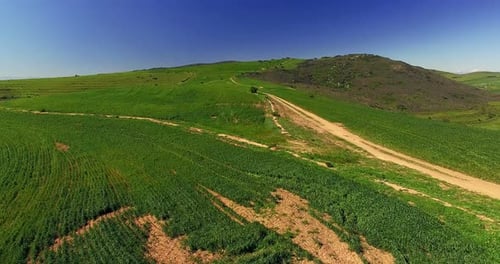 Aerial view of a dirt road winding through mountainous terrain
