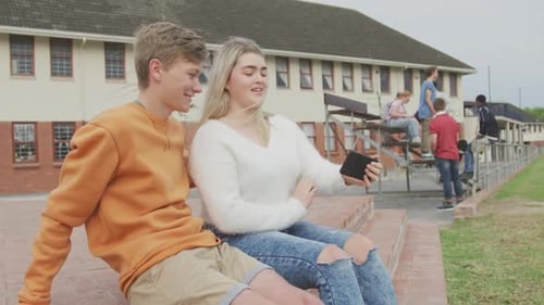 Students couple taking selfie together in high school