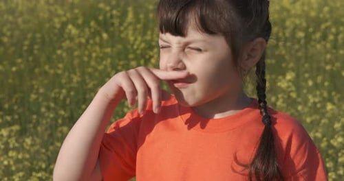 Child Sneezing in Field of Yellow Flowers