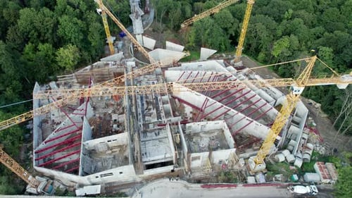 Aerial View Construction of a New Building with High Tower Cranes in Green Area