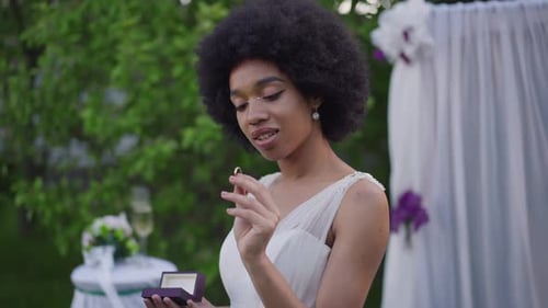 Bride Smiles Holding Wedding Ring Outdoors