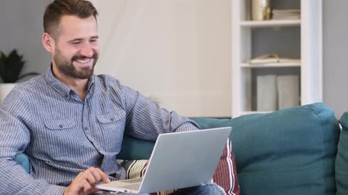 Man Relaxing on Couch Using Laptop Computer