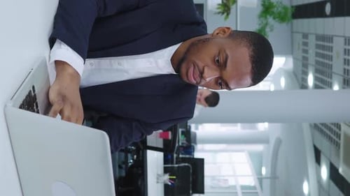 Vertical Screen Black Businessman Working on Laptop in Open Space Office