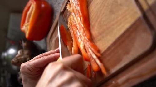 Slicing Red Bell Pepper on Wooden Board