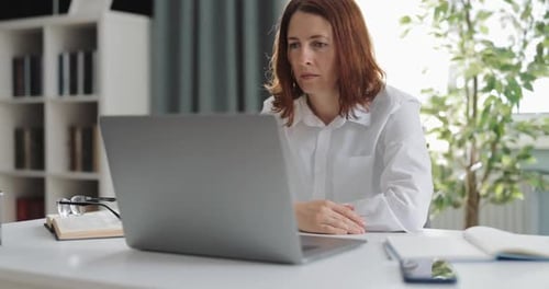 Woman Working on Laptop in Bright Office