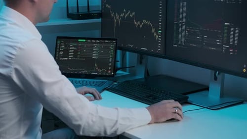 Close up of young Caucasian man trader working at monitor computer and browsing online