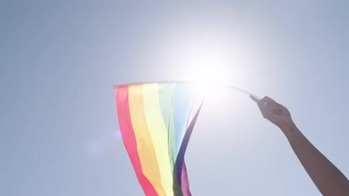 Pride Flag Waving Freely in Blue Sky