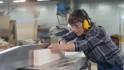 Woodworker Using Industrial Wood Saw Machine in Workshop