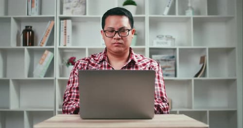 Man Working on Laptop at Home Office Desk