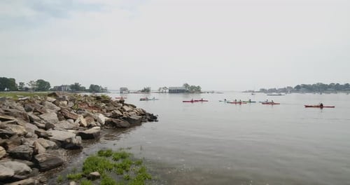 Un grupo de kayakistas remando en un lago en un día nublado