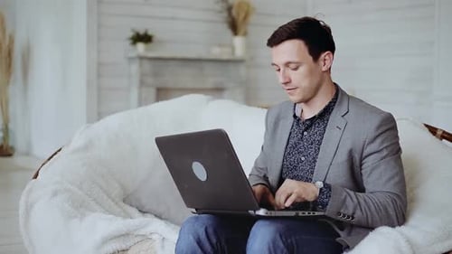 Man Working on Laptop in Comfortable Chair