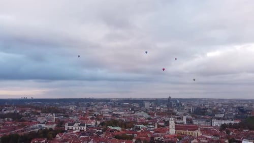 Hot Air Balloons Flying Over City Of Vilnius In Lithuania Under Cloudy Sky. wide aerial