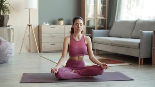 Woman Meditating in Lotus Position at Home
