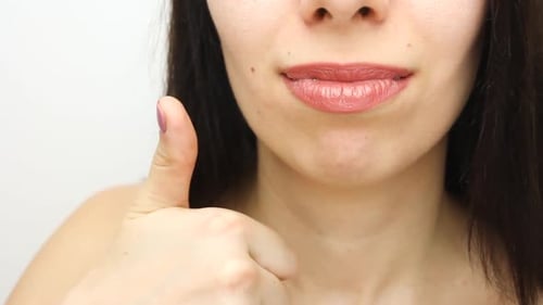 Person With Braces Smiles and Gives Thumbs Up