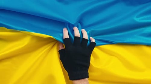 Hand Holds Flag of Ukraine
