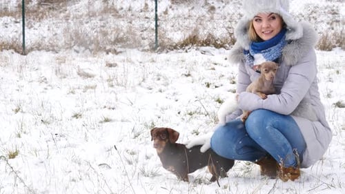 Mujer jugando con perros en invierno