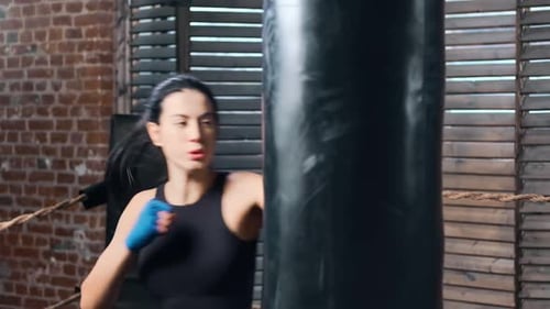 Powerful Brunette Female Mma Fighter Punch and Kick Punching Bag During Training at Gym Slow Motion