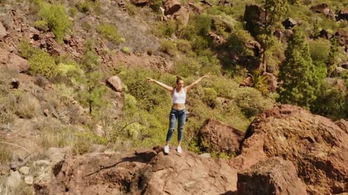 Aerial Shot of the Valley with Green Trees and a Beautiful Happy Woman