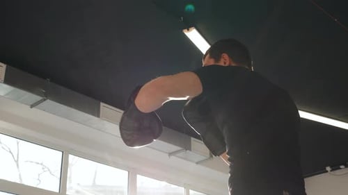 Mann kämpft mit seinem Schatten vor Ängsten Boxtraining im Fitnessstudio in Handschuhen Power Mma Fighter