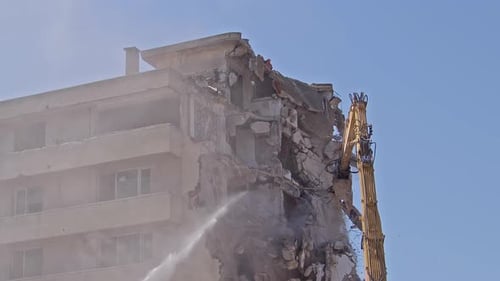 Excavator Demolishing a Building on a Clear Day
