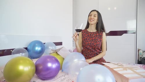 Woman Celebrating Birthday with Wine and Balloons