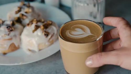 Hand Taking Latte Drink With Cinnamon Buns