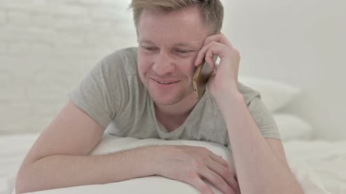 Man Speaking on The Phone While in Bed