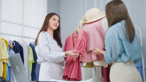 Asian two tailor woman working to design clothes in tailoring atelier.