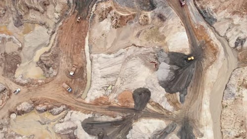 Cantera industrial de minería a cielo abierto con mucha maquinaria en funcionamiento.