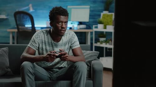 Young Adult Playing Video Game at Home