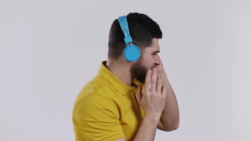 Active Young Man Listening to Music with Wireless Headphones Guy Having Fun Dancing in Studio on
