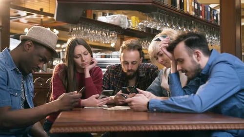 Friends Use Smartphones at Cafe Table