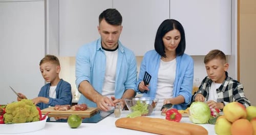 Family Cooking a Healthy Meal Together in Kitchen