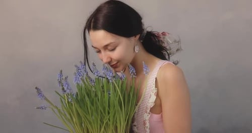 Woman With Purple Flowers Smelling Fragrance Indoors