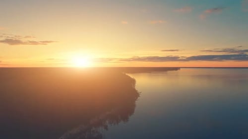 Drohnenaufnahme aus der Luft: Sonnenuntergang über Wasser und Wald