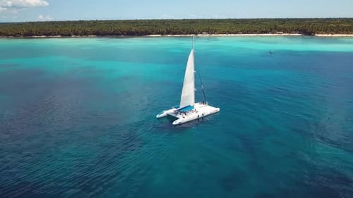 drone shoot of the catamaran in the saona island in the caribbean sea with blue water in a sunny day
