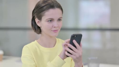 Young Woman Using Smartphone in Office Setting