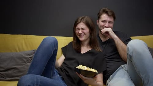 Couple Laughing Together and Eating Popcorn
