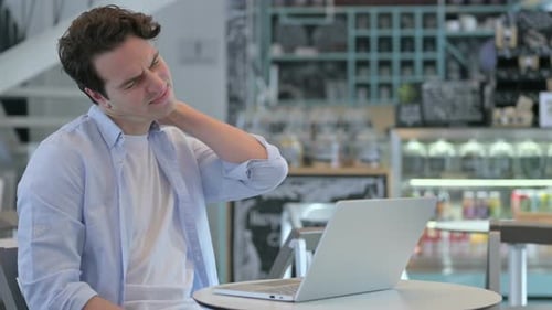 Young Man Experiencing Neck Pain While Using Laptop