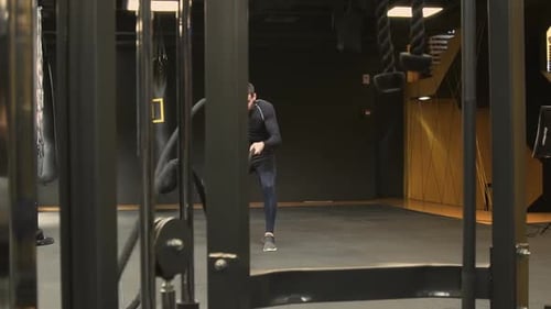 Athletic Young Man Working Out in Gym with Battle Ropes