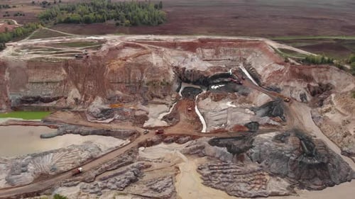 Un camión minero transporta arena en una cantera de arena. La maquinaria minera se mueve en la cantera de arcilla.