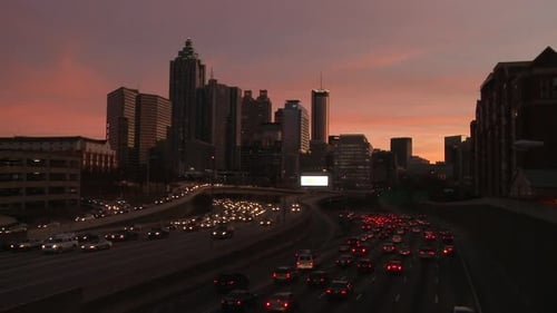 Static, wide, nighttime shot of the Atlanta Skyline with traffic below.