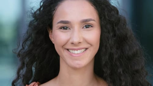 Close Up Portrait Outdoors in City Curly Haired Brunette Hispanic Ethnic Mixed Race Woman Happy