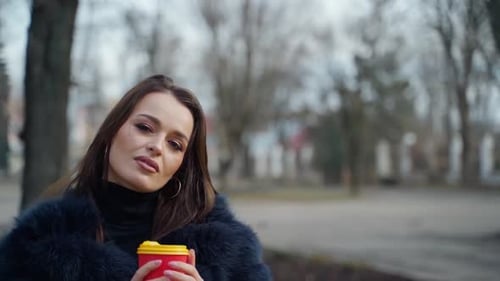 Woman in Fur Coat Walks Through Park