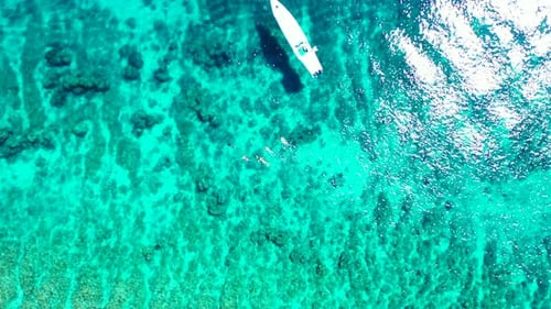 Wide overhead island view of a white sandy paradise beach and aqua blue water background in high res