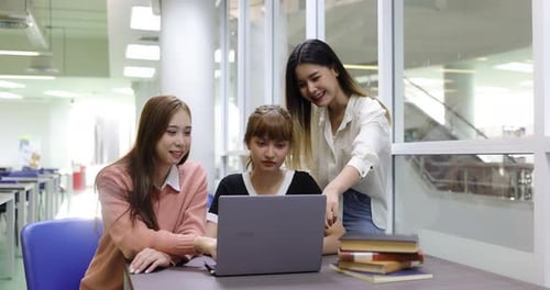 Group of Asian college student girl meeting and making education project together in library.