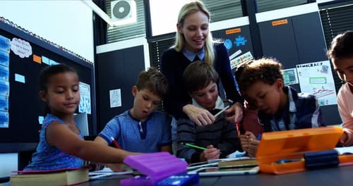 Teacher Helping Students in Classroom