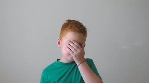 Young Upset Kid Touching His Face Expressing a Desperate. Close Up Emotions of Male Child with Sad